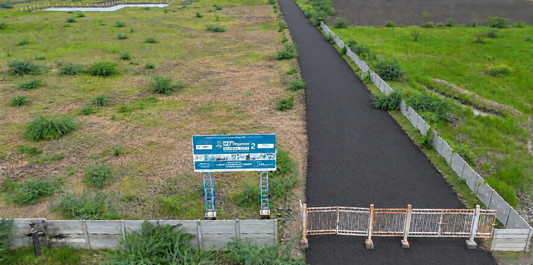 Global City 2 entrance gate, project billboard and the approach road