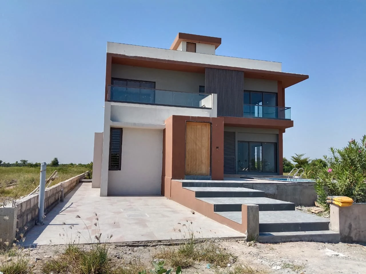 The front of the Lakeside Meadows villa with its balcony, entrance and outdoor steps